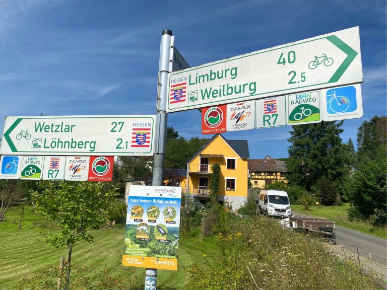 Wegweiser mit Kilometerangaben nach Wetzler und Limburg dahinter unser gelbes Haus